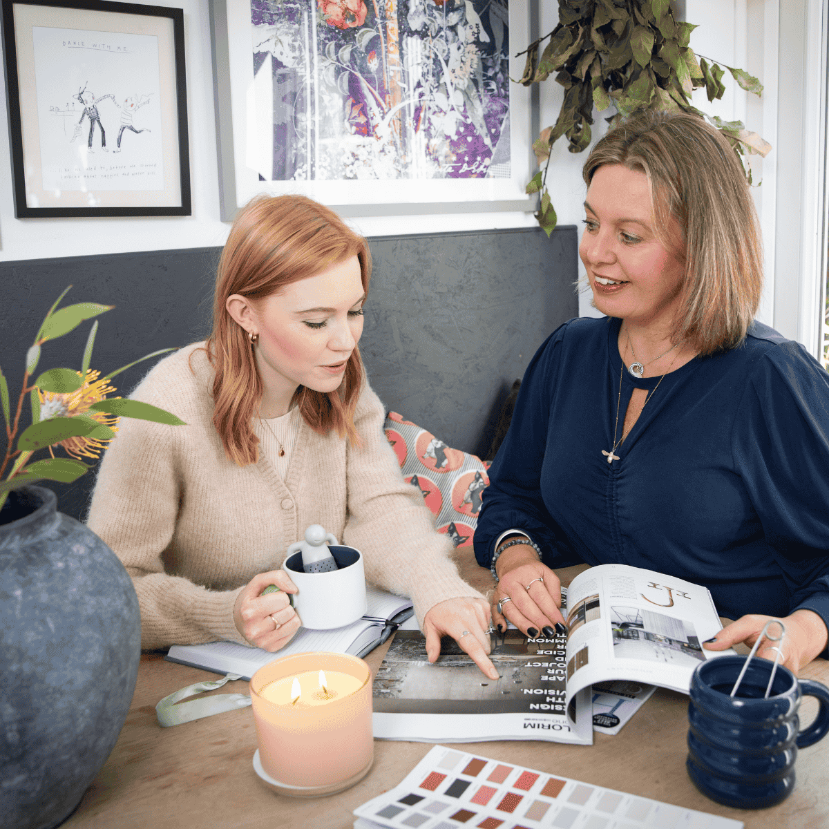 Gini and Ruby talking at table with colour books and magazines